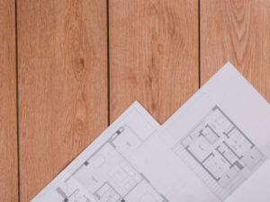 disegni di progetto appoggiati su un pavimento in parquet